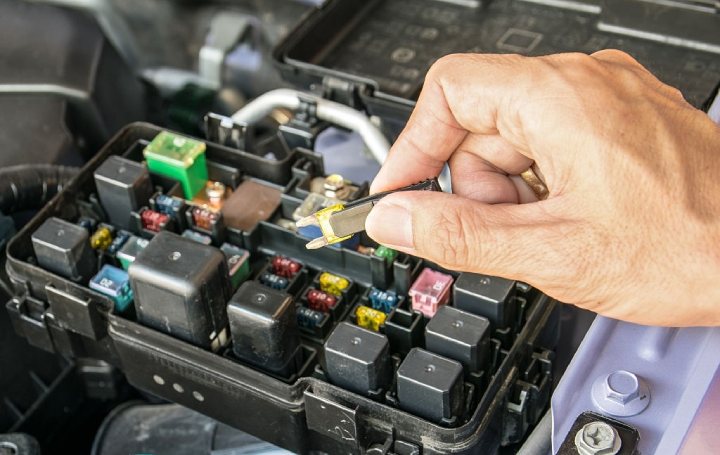 mechanic changing a fuse