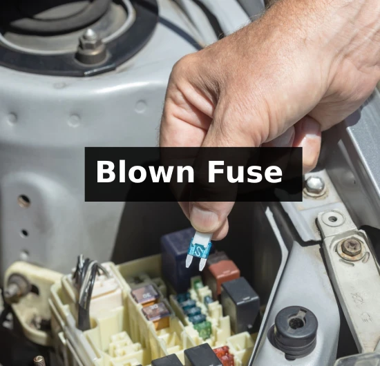 mechanic changing blown fuse